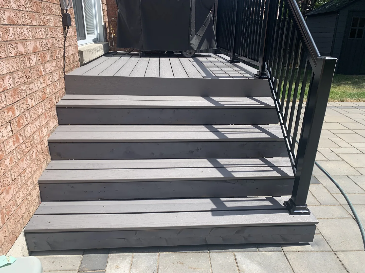 Grey composite entry steps with black exterior railing