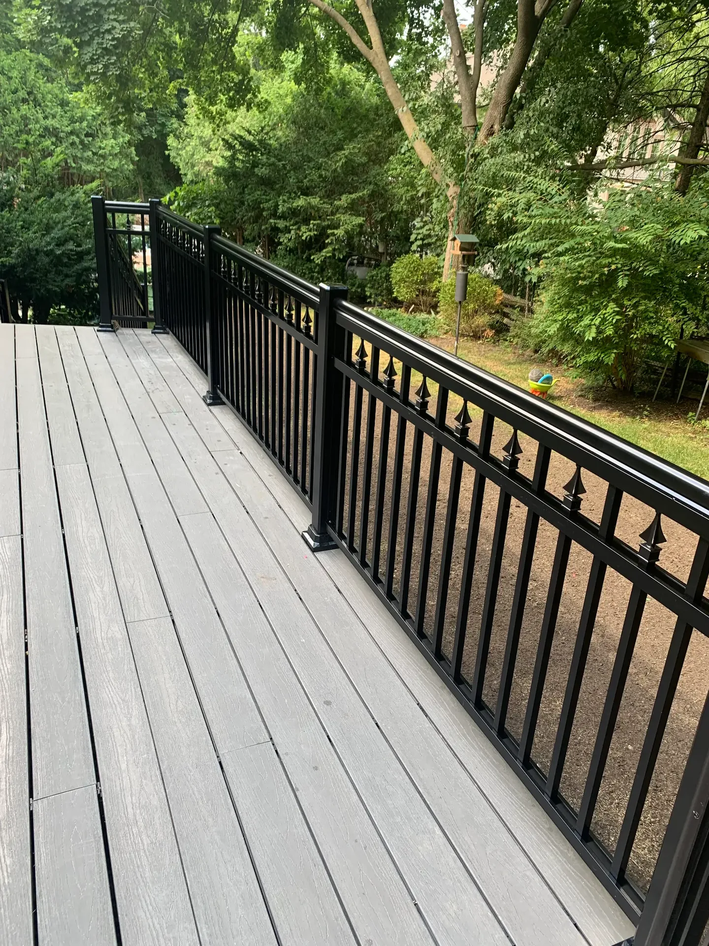 Black metal railing along a grey deck