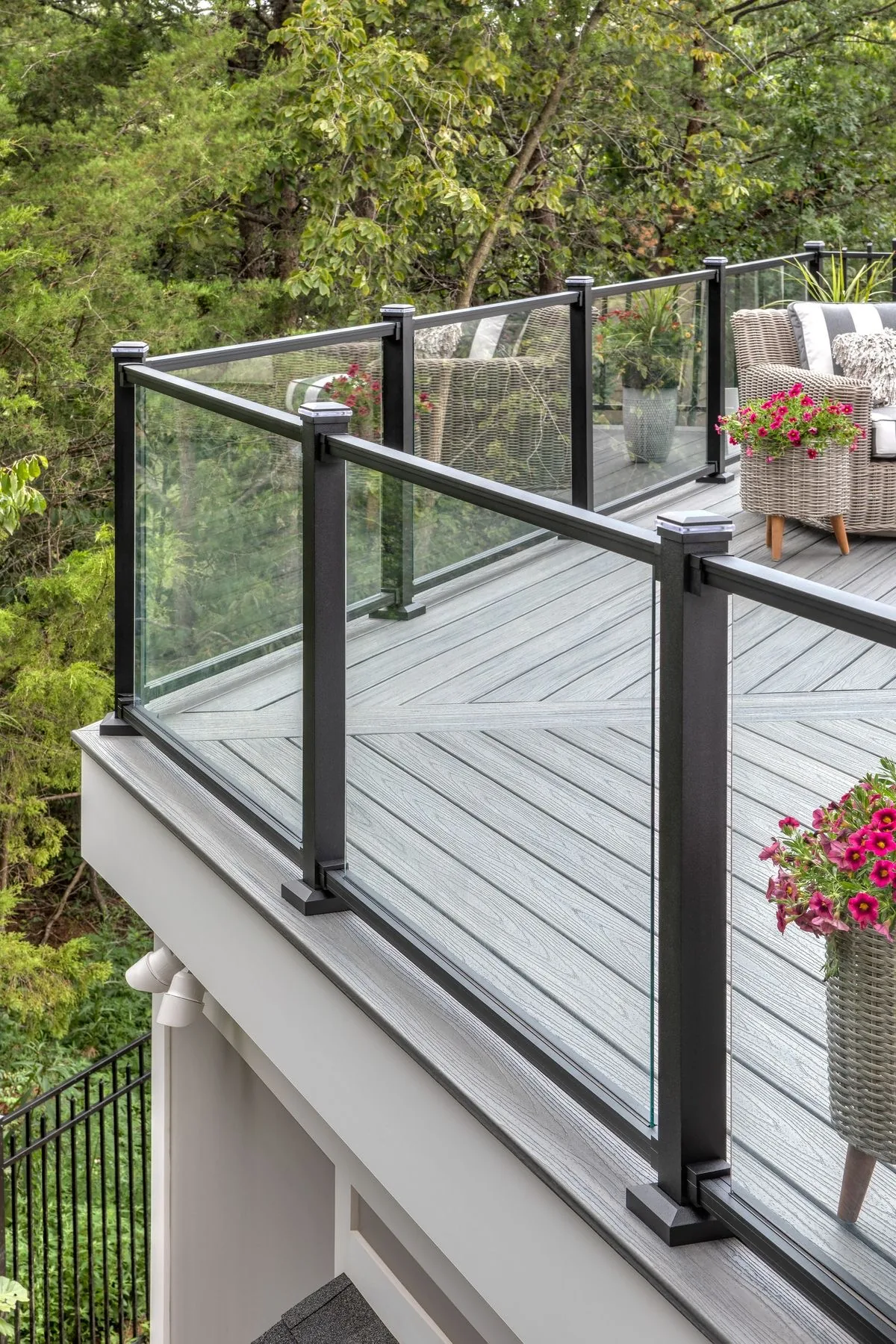 Black framed glass-panel railing around a deck